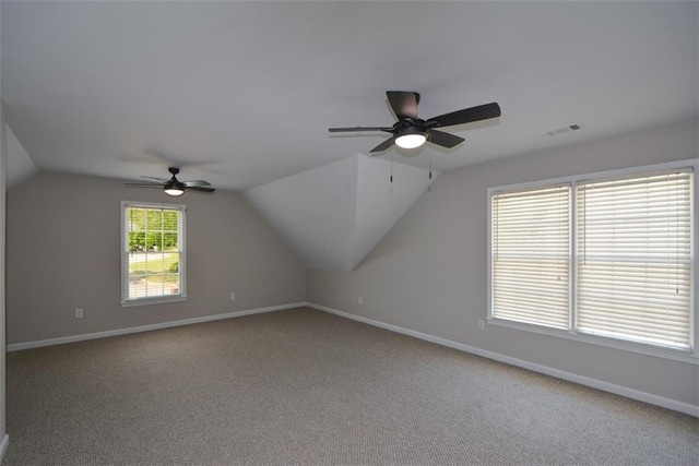additional living space with carpet, a ceiling fan, vaulted ceiling, visible vents, and baseboards