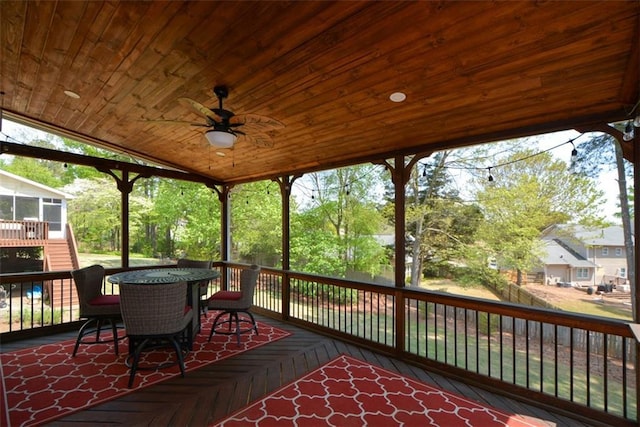 wooden deck with a sunroom and a ceiling fan