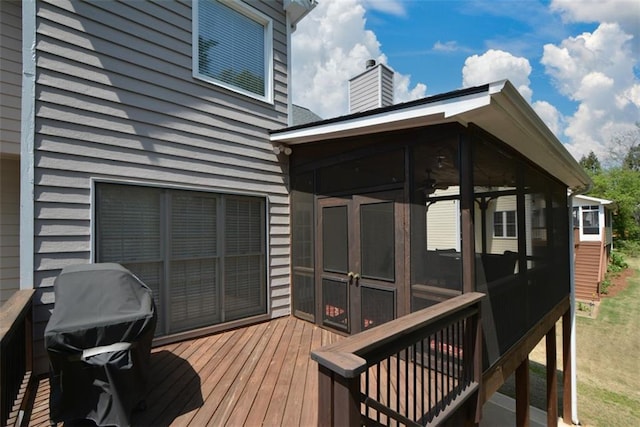 wooden deck with a sunroom and grilling area