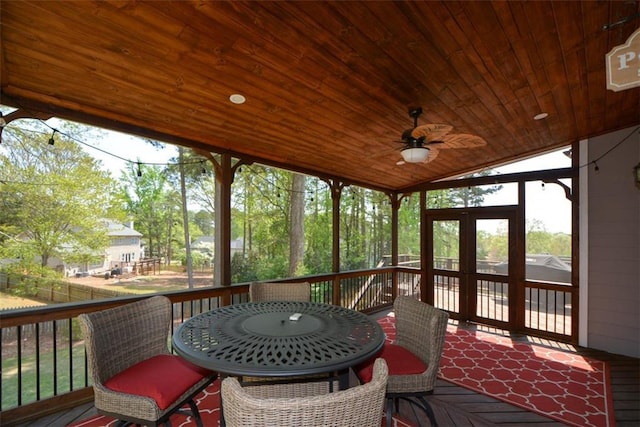 sunroom / solarium with outdoor dining area and ceiling fan