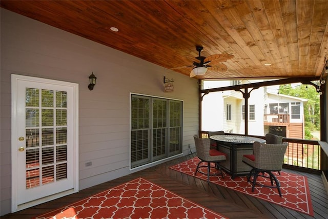 deck with outdoor dining space and a ceiling fan