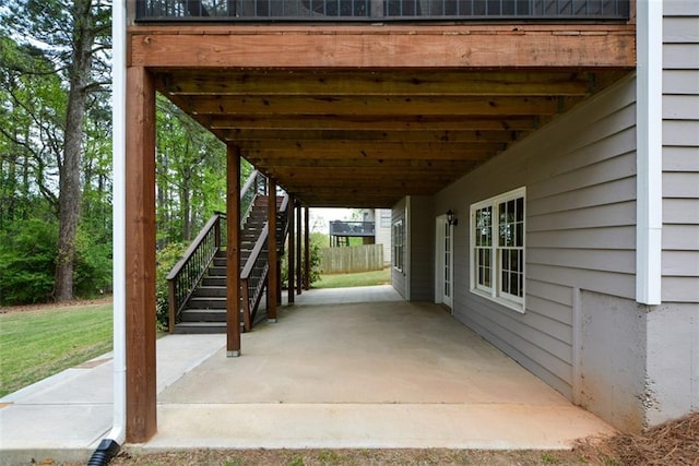 view of patio with stairs, a carport, and fence