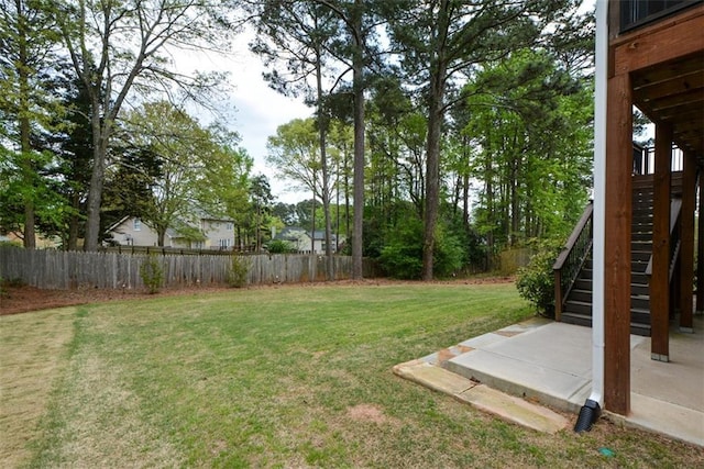 view of yard with fence, stairway, and a patio