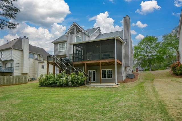 back of property featuring a sunroom, central air condition unit, a yard, stairway, and a patio area