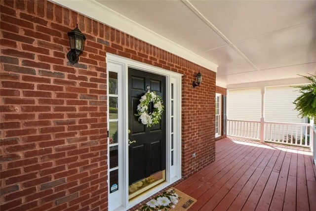 property entrance with brick siding and covered porch