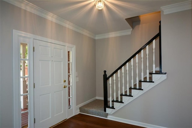 foyer entrance with stairs, baseboards, ornamental molding, and wood finished floors
