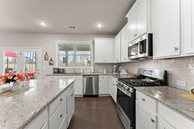 kitchen with white cabinetry, sink, stainless steel appliances, and light stone countertops