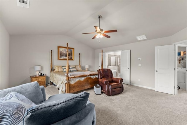 bedroom with lofted ceiling, ensuite bath, light carpet, ceiling fan, and washer / clothes dryer