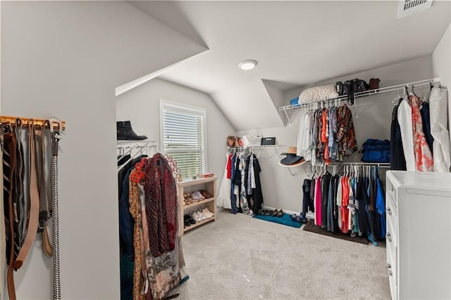 walk in closet featuring lofted ceiling and light colored carpet