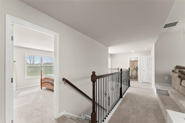 hallway featuring light colored carpet