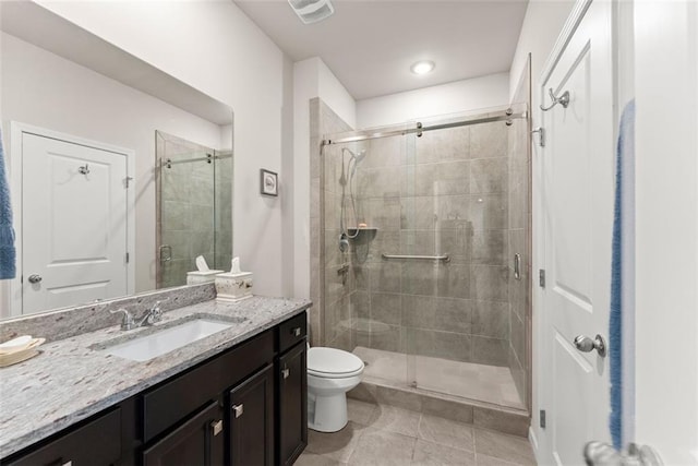 bathroom with vanity, tile patterned flooring, toilet, and walk in shower