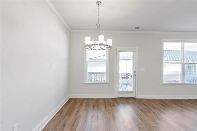 interior space with plenty of natural light, baseboards, crown molding, and wood finished floors