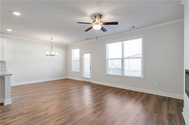 unfurnished living room featuring baseboards, visible vents, and ornamental molding