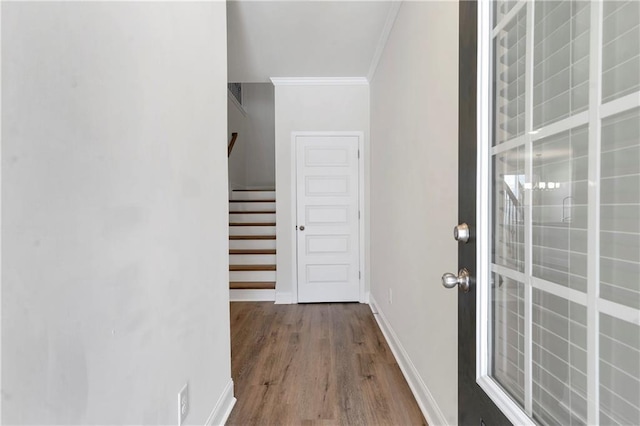 interior space with stairs, ornamental molding, wood finished floors, and baseboards