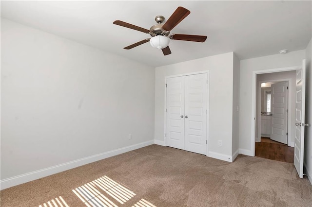 unfurnished bedroom with a ceiling fan, carpet, a closet, and baseboards