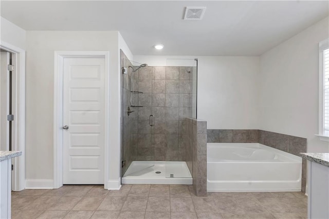 bathroom with tile patterned flooring, vanity, visible vents, a shower stall, and a bath