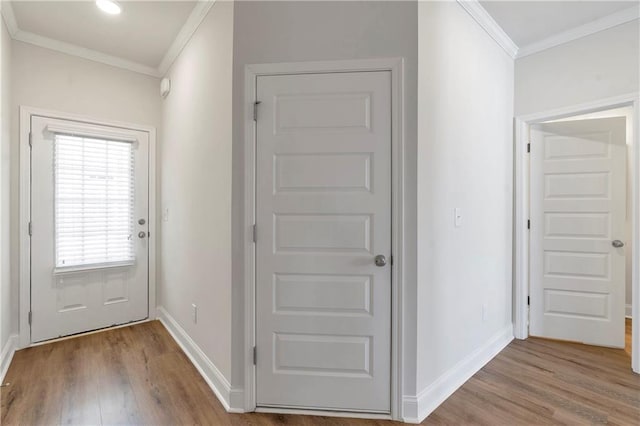 interior space featuring baseboards, wood finished floors, and crown molding