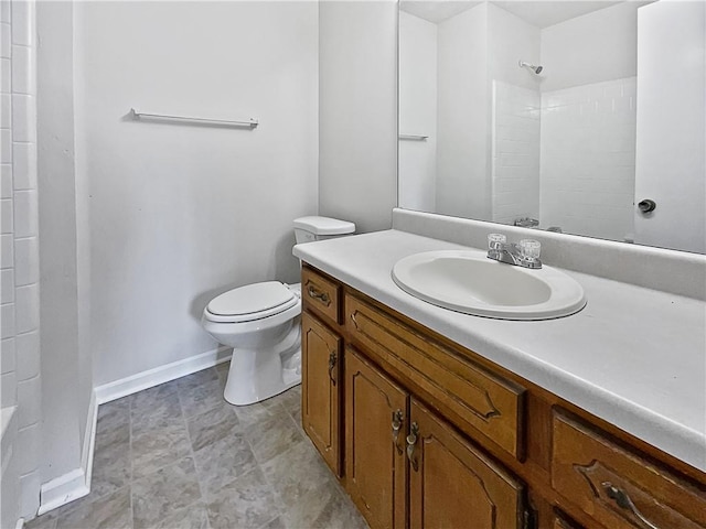 bathroom with walk in shower, vanity, and toilet