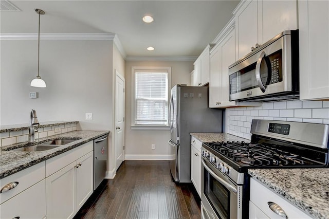 kitchen featuring light stone countertops, sink, decorative light fixtures, white cabinets, and appliances with stainless steel finishes