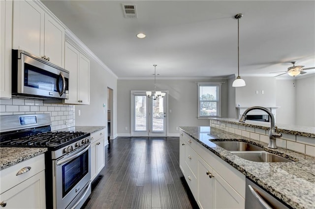 kitchen with pendant lighting, white cabinetry, sink, and appliances with stainless steel finishes