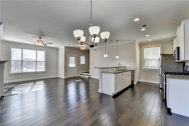 kitchen featuring dark stone countertops, white cabinetry, ceiling fan with notable chandelier, and decorative light fixtures