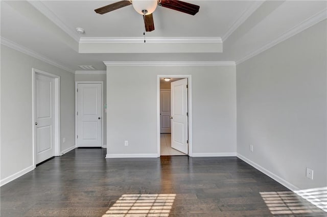 unfurnished room featuring a raised ceiling, ceiling fan, and dark hardwood / wood-style floors