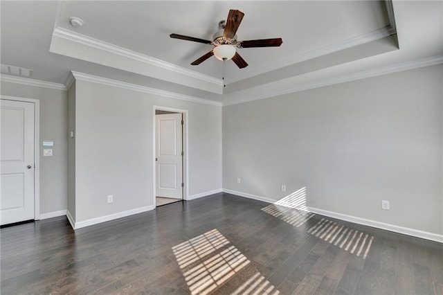 spare room with dark wood-type flooring, a raised ceiling, ceiling fan, and crown molding