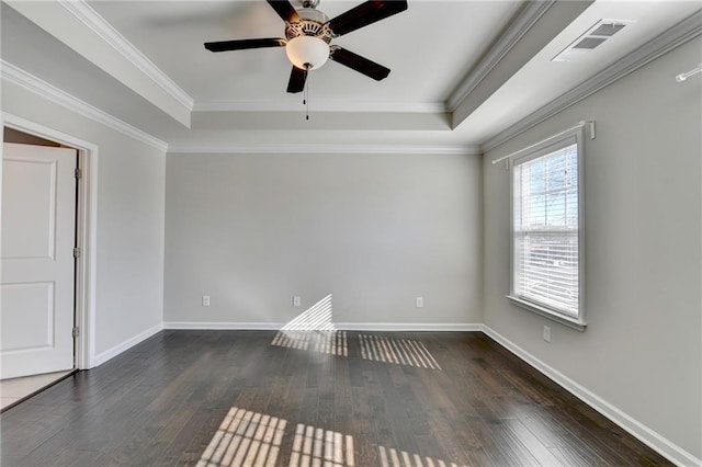 spare room featuring ceiling fan, dark hardwood / wood-style floors, ornamental molding, and a tray ceiling