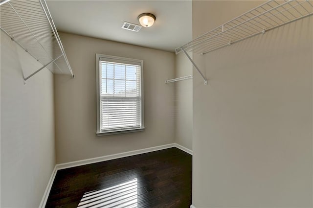 walk in closet with dark wood-type flooring