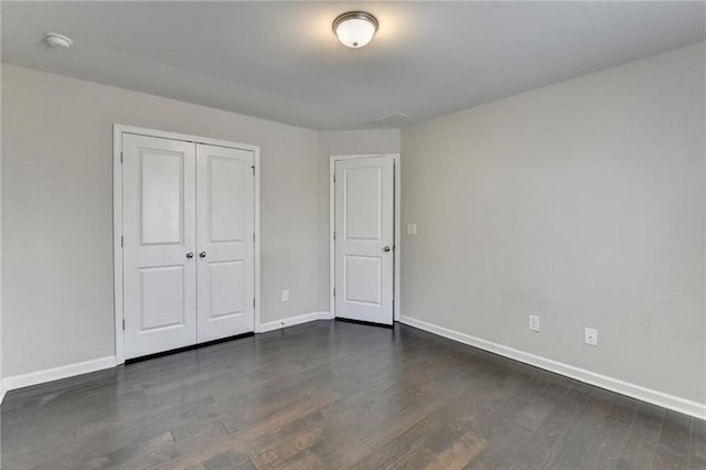 unfurnished bedroom featuring a closet and dark hardwood / wood-style floors