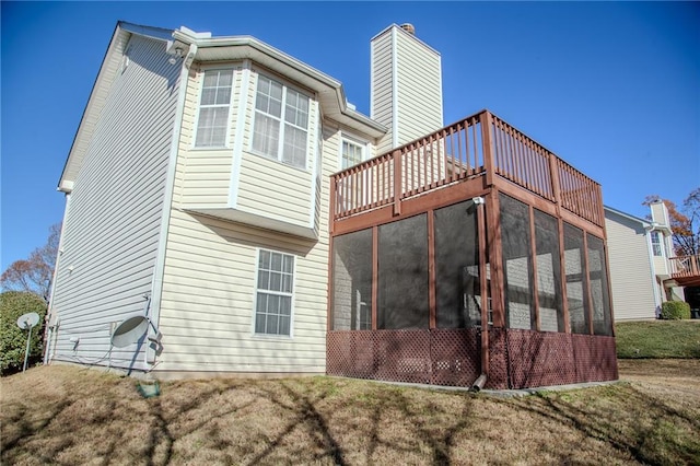 rear view of house with a sunroom and a lawn