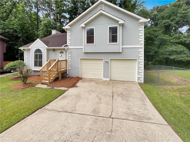 320 Rebecca Lake Way, Fairburn, GA 30213 - tri-level home featuring an attached garage, driveway, stucco siding, a chimney, and view of wooded area