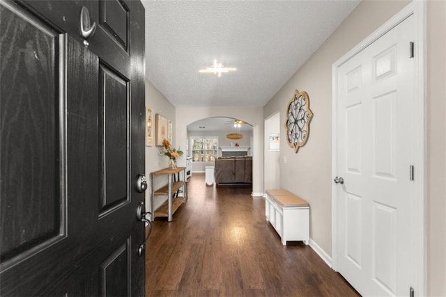 hallway with dark wood-type flooring and a textured ceiling