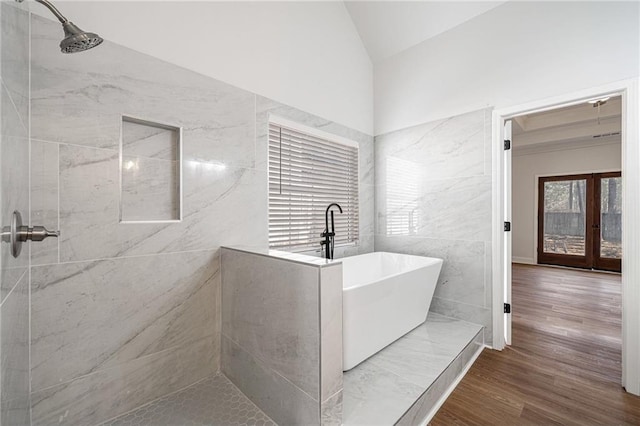 3850 Laurel Dr NW, Acworth, GA 30101 - full bathroom featuring a soaking tub, tiled shower, vaulted ceiling, wood finished floors, and tile walls