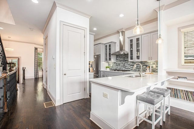 1216 Virginia Ct NE Unit 8, Atlanta, GA 30306 - kitchen featuring wall chimney range hood, a sink, gray cabinetry, stainless steel gas cooktop, and a kitchen bar