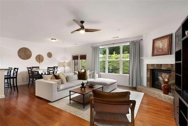 6038 Mayfield Way SE, Mableton, GA 30126 - living area featuring a ceiling fan, a fireplace, and wood finished floors