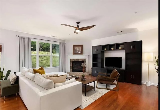 6038 Mayfield Way SE, Mableton, GA 30126 - living area with wood finished floors, a ceiling fan, and a stone fireplace