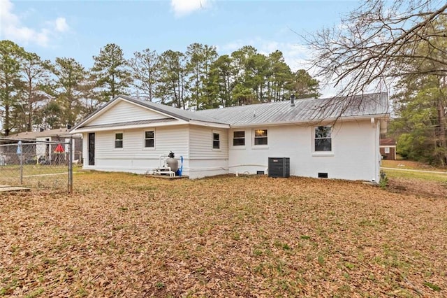 back of property featuring central air condition unit, a lawn, crawl space, metal roof, and fence