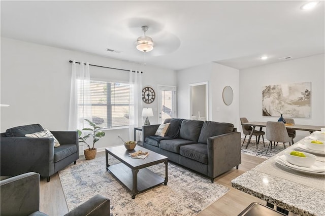 living room with ceiling fan and light hardwood / wood-style floors