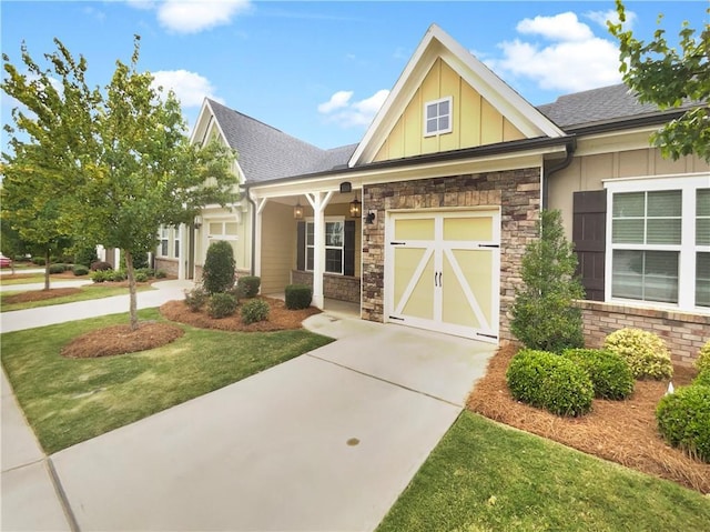 craftsman inspired home featuring a garage and a front lawn