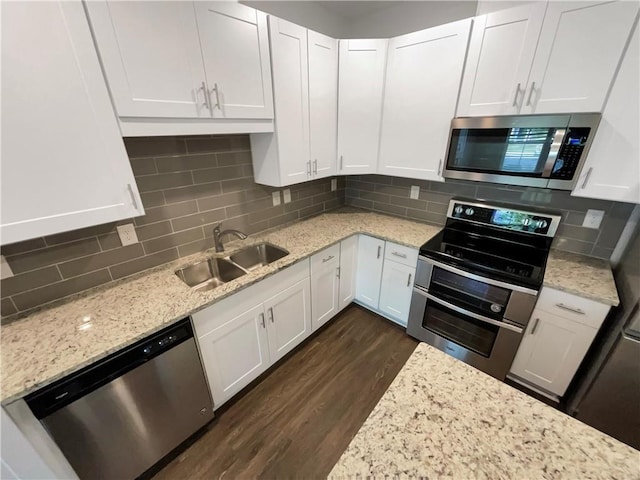 kitchen featuring backsplash, stainless steel appliances, white cabinetry, and sink