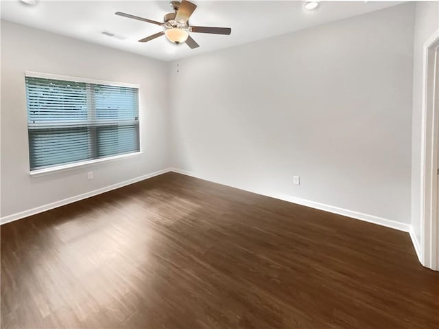 empty room with ceiling fan and dark hardwood / wood-style floors