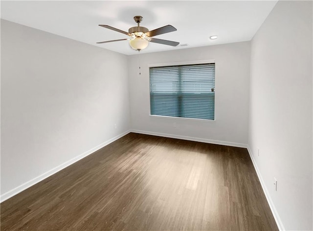 empty room with ceiling fan and dark wood-type flooring