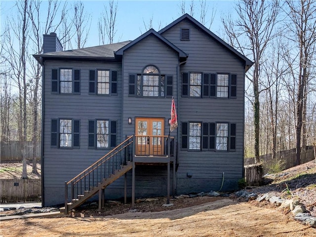 view of front of home with fence, a chimney, and stairs