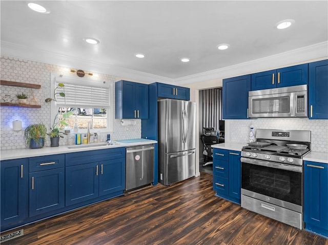 kitchen with dark wood-style flooring, blue cabinetry, stainless steel appliances, ornamental molding, and a sink