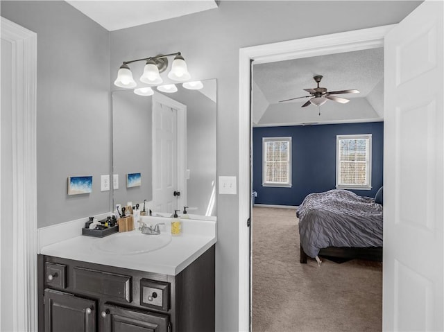 bathroom with lofted ceiling, ceiling fan, a textured ceiling, and vanity