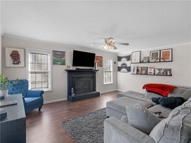 living area with crown molding, a textured ceiling, a wealth of natural light, and wood finished floors