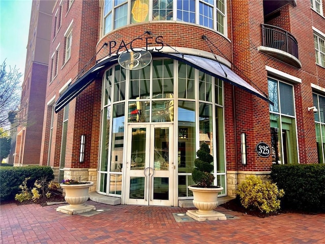 view of exterior entry with brick siding and french doors