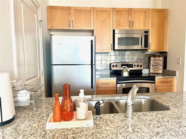 kitchen with light stone counters, tasteful backsplash, and appliances with stainless steel finishes