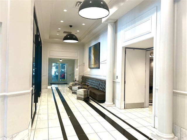 hallway featuring light tile patterned floors, visible vents, a tray ceiling, decorative columns, and recessed lighting